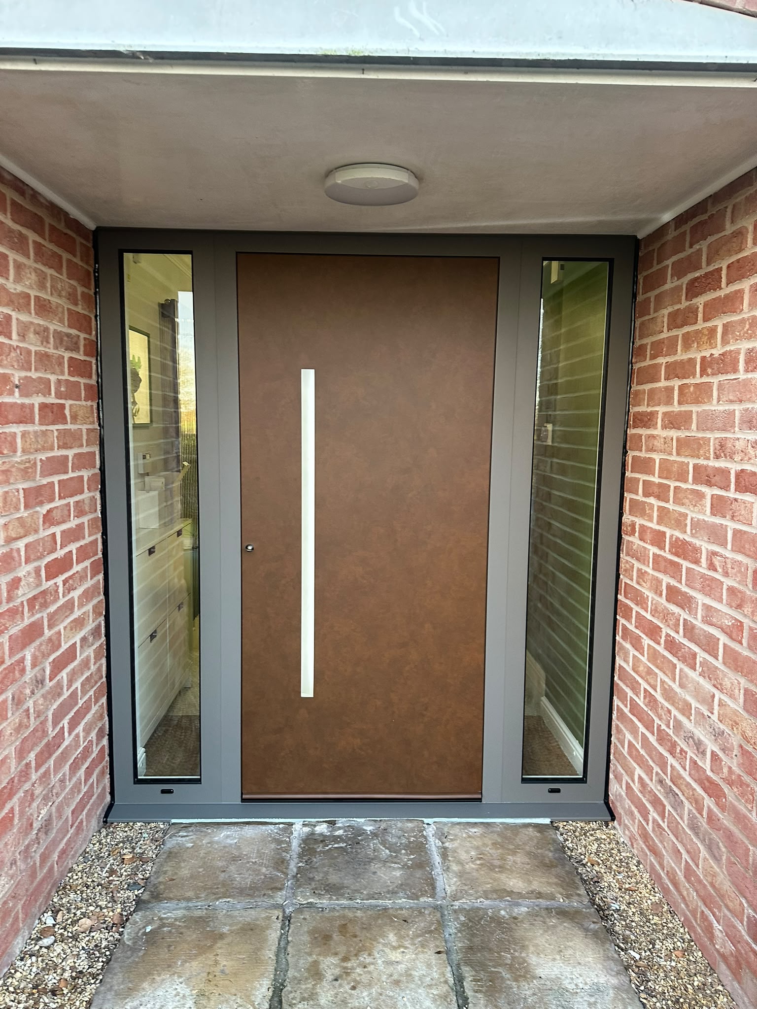 A warm-toned entrance framed by two glazed sidelights.