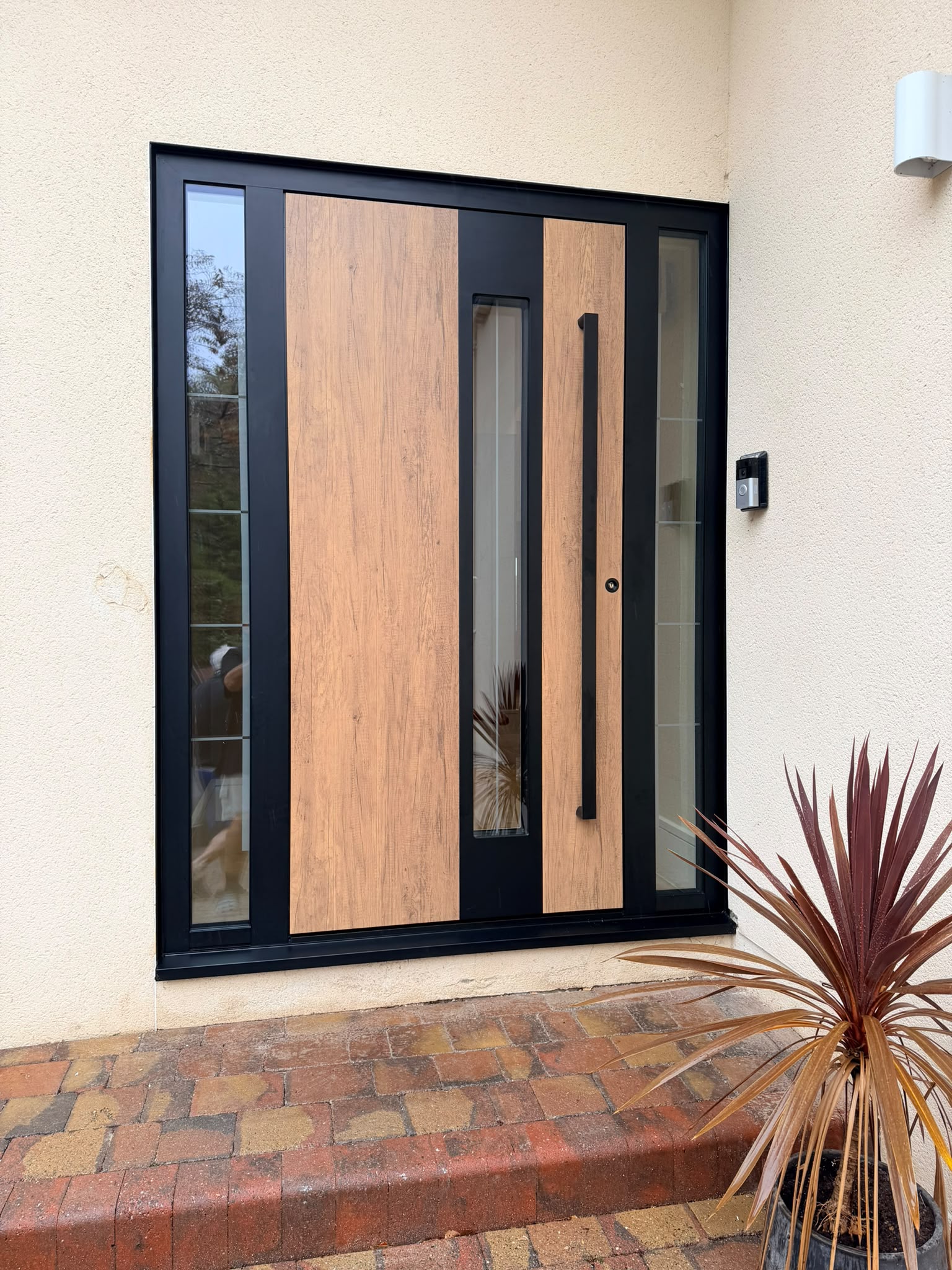 Wood-effect panels, a long pull handle and glazed sidelights.