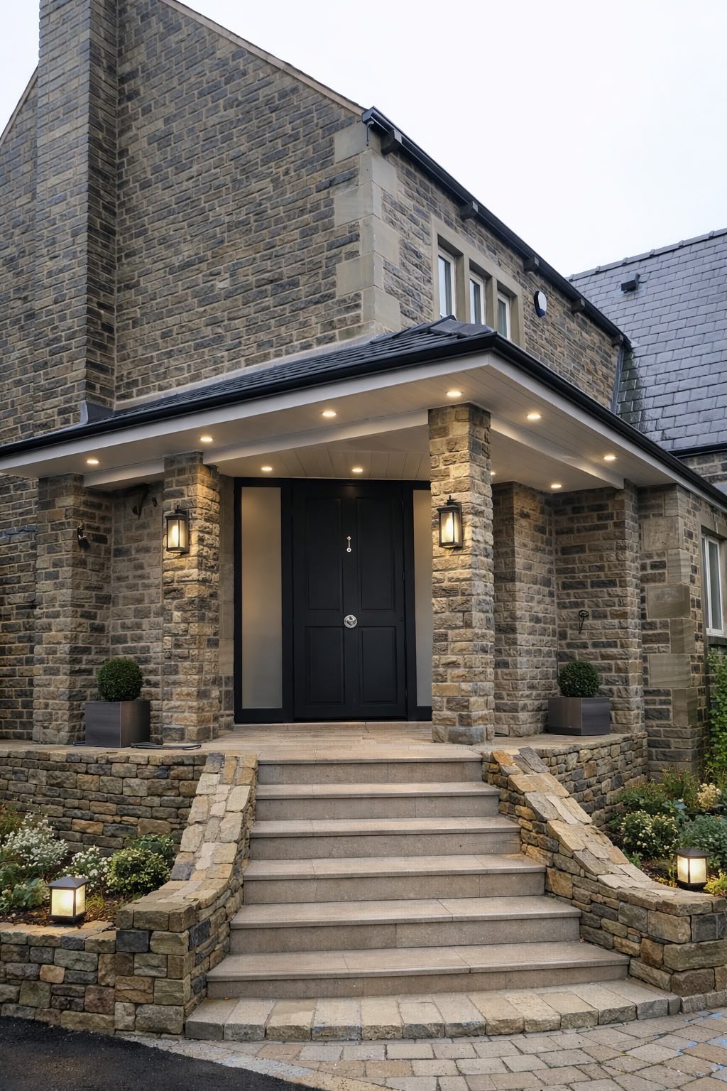 A dark entrance door beneath a canopy on a stone property.